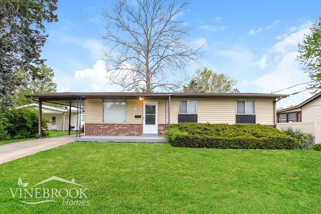 A Vinebrook Homes house with a green lawn and a tree in the background.