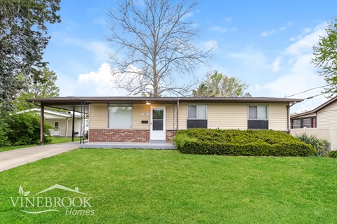 A Vinebrook Homes house with a green lawn and a tree in the background.