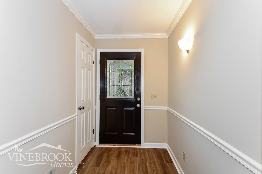 a view of a hallway with a black door and white walls