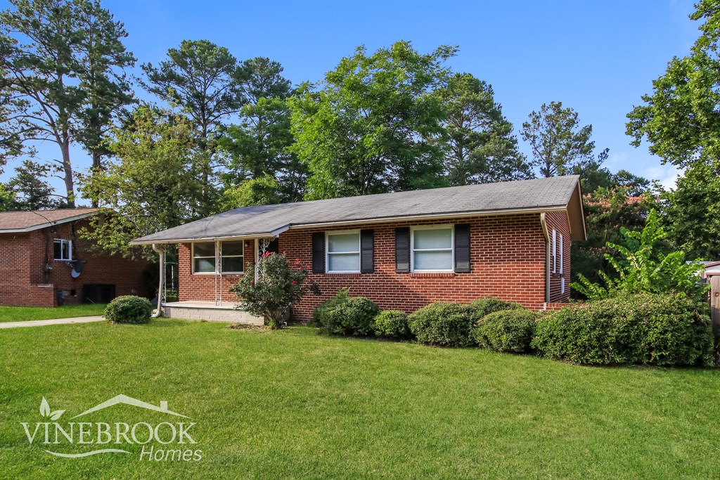a small brick house with a lawn in front of it