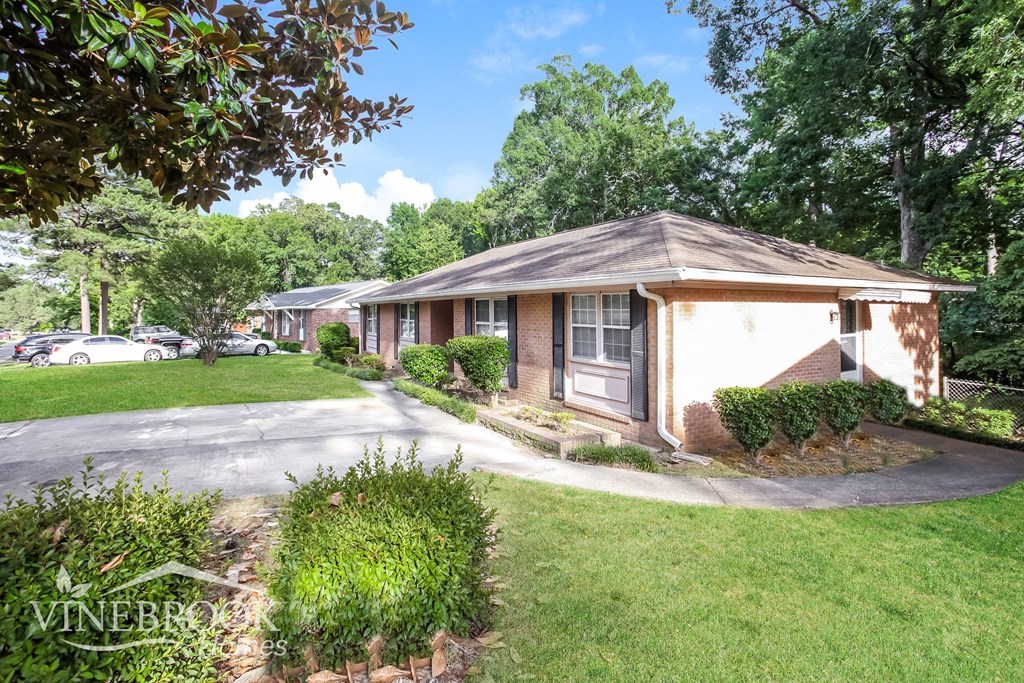 a small house with a driveway and a street in front of it