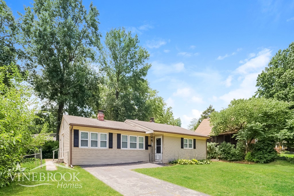 a small house with a lawn and a driveway