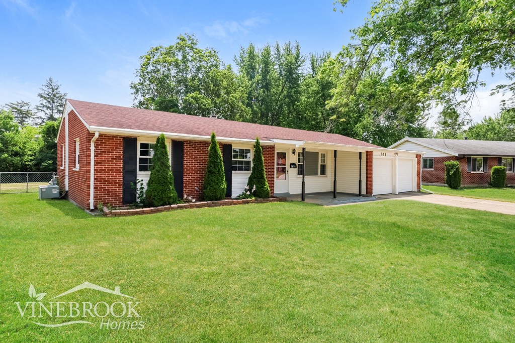 a small brick house with a lawn in front of it