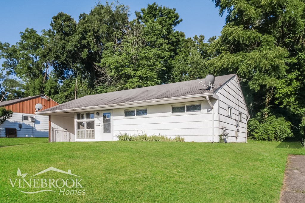 a white and white house in the middle of a grass field