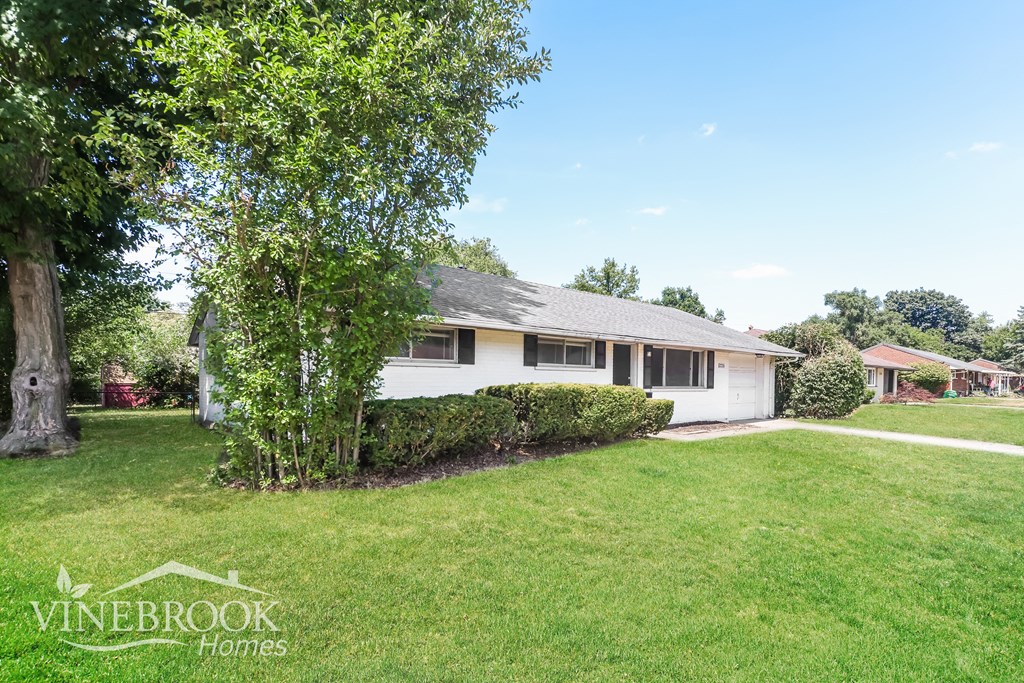 a white house with a yard and a tree