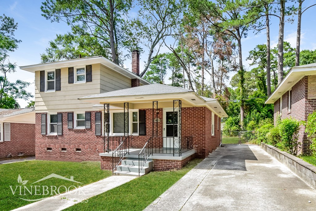 a brick house with a driveway and a porch