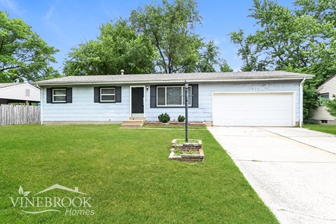 a small white house with a lawn in front of it