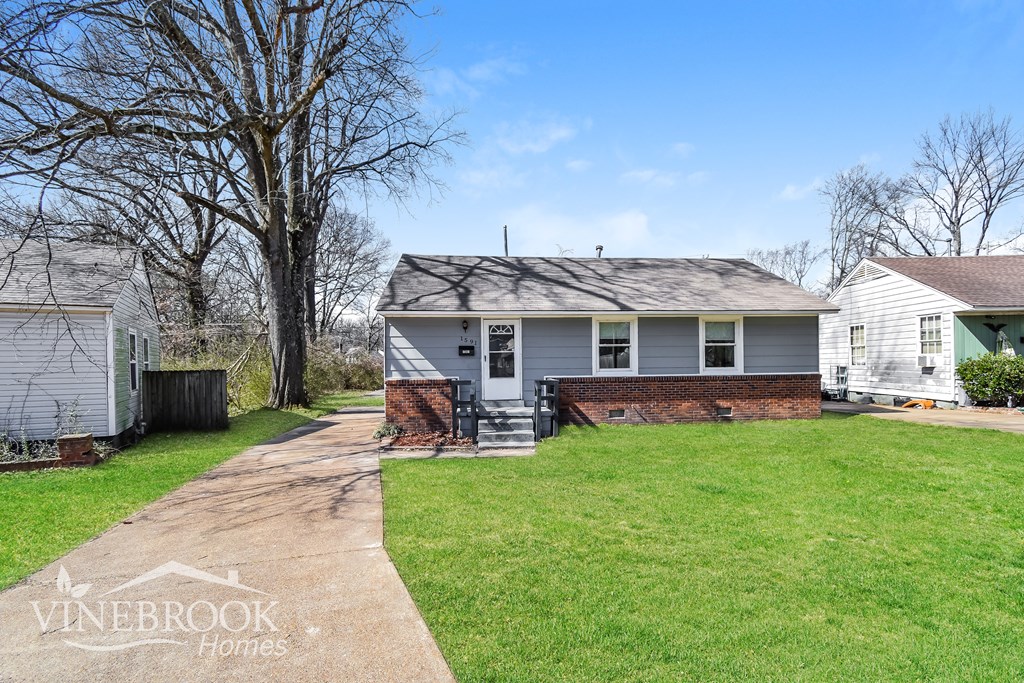 A house with a lawn in front of it and a sign that says Vinebrook Homes.