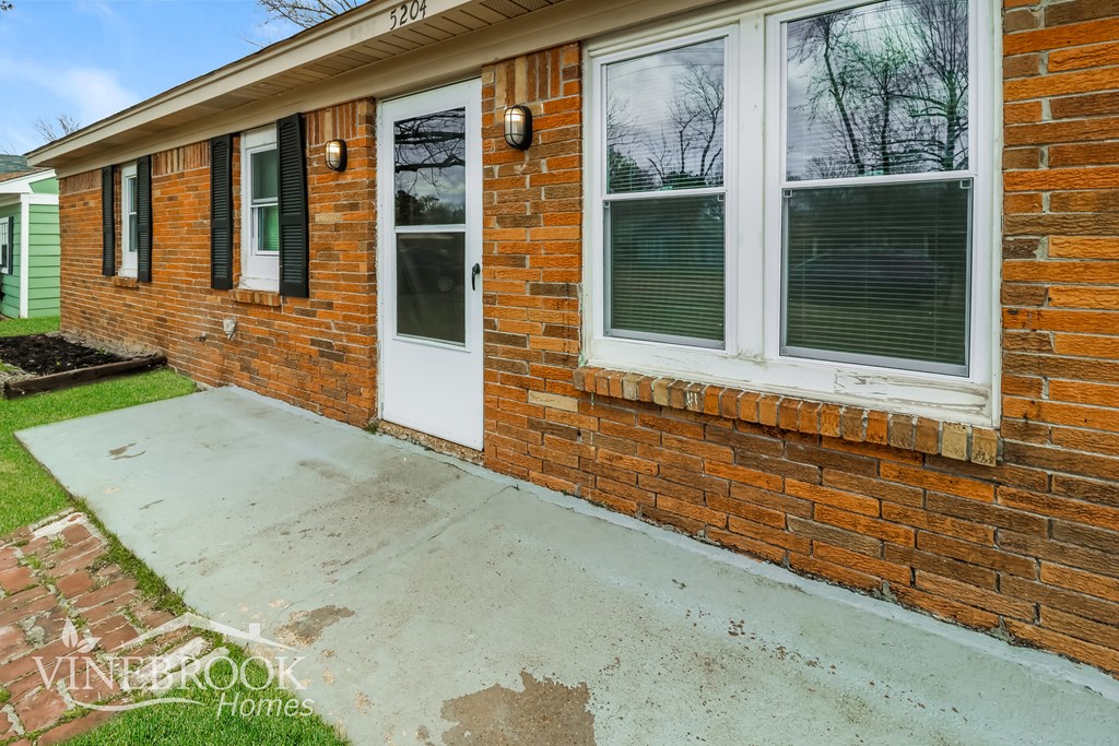 A brick house with a white door and windows.