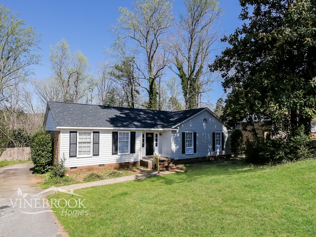 A house with a white front porch and a sign that says Vinebrook Homes.