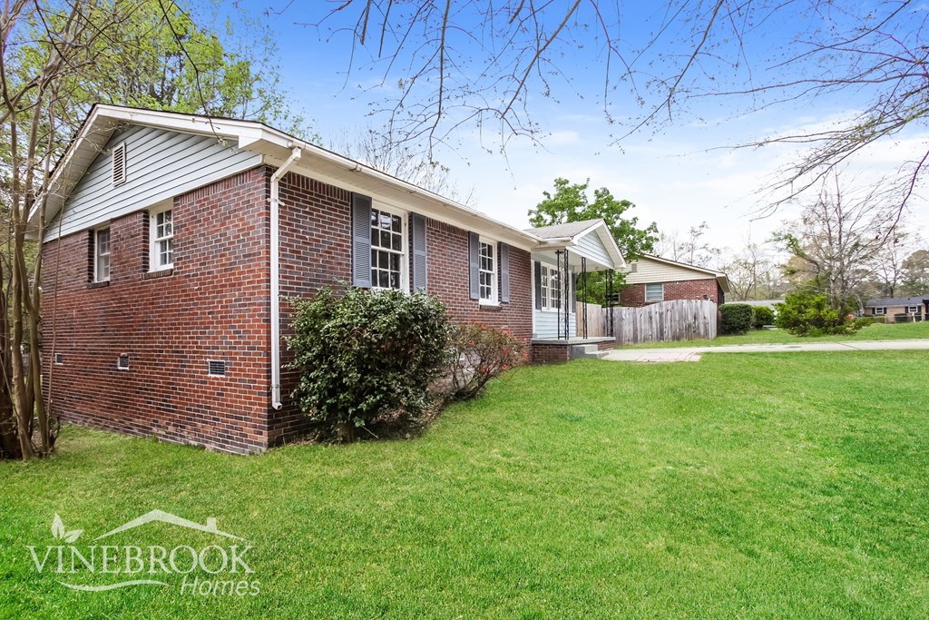 A brick house with a sign that says Vinebrook Homes.