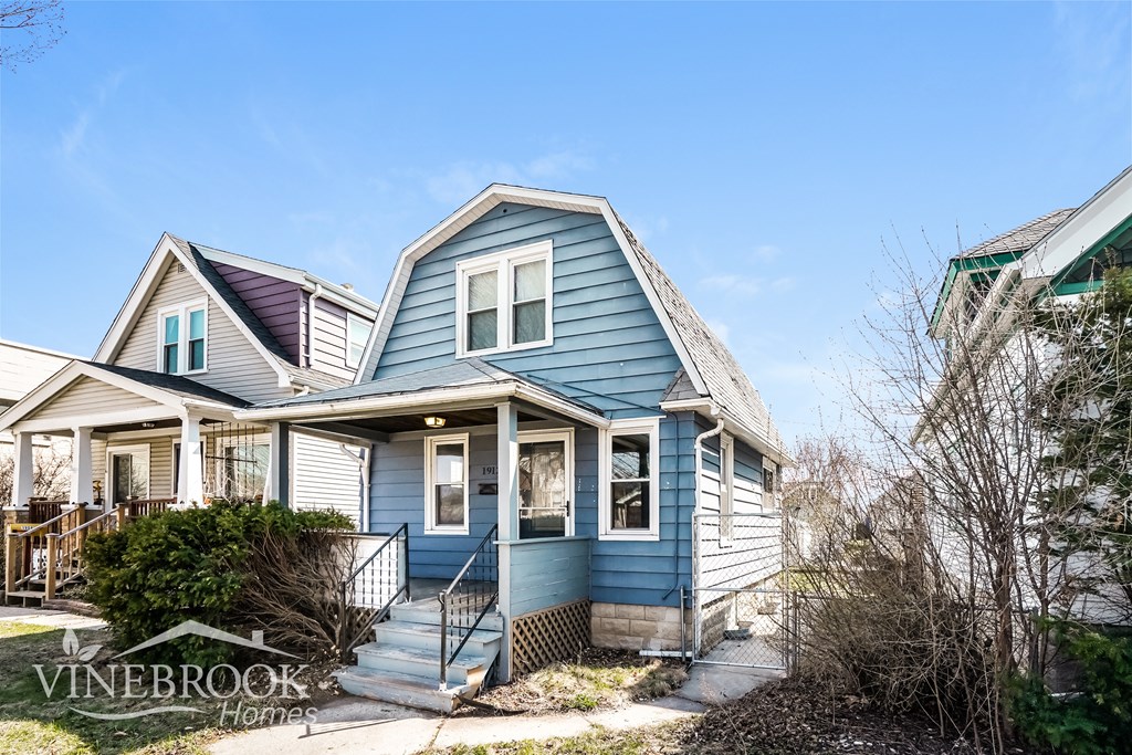 A blue house with a sign that says Vinebrook Homes.