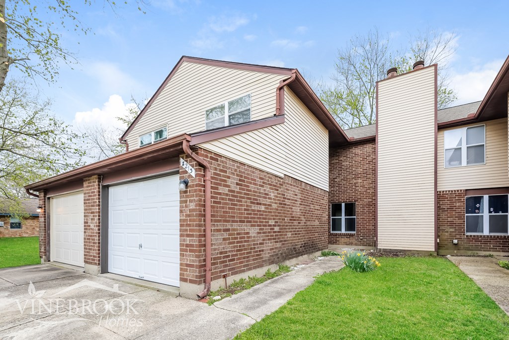 A house with a garage and a driveway in front.