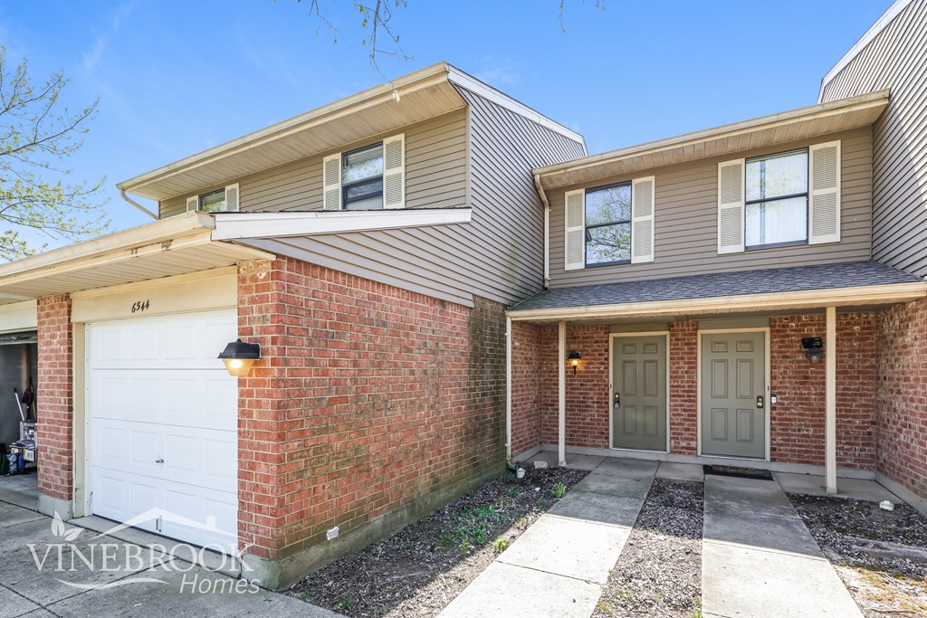 A house with a garage and a driveway in front.