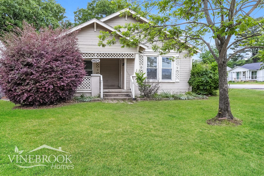A house with a tree in front of it.