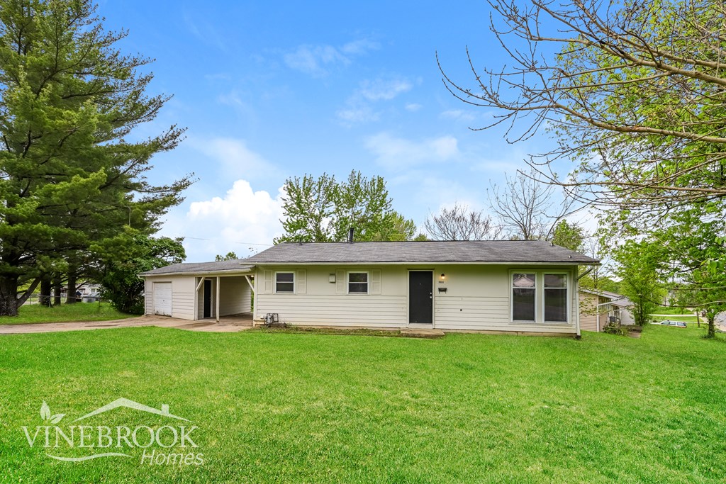 A Vinebrook Homes house with a green lawn and trees in the background.