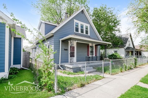 A blue house with a sign that says Vinebrook Homes.