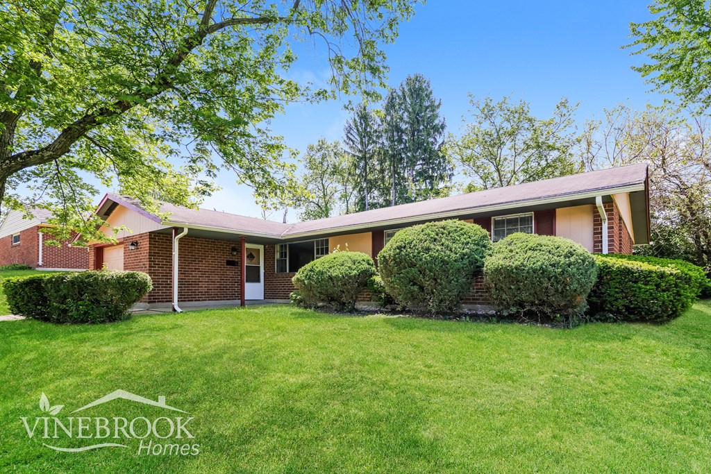 A house with a lawn and trees in front of it.