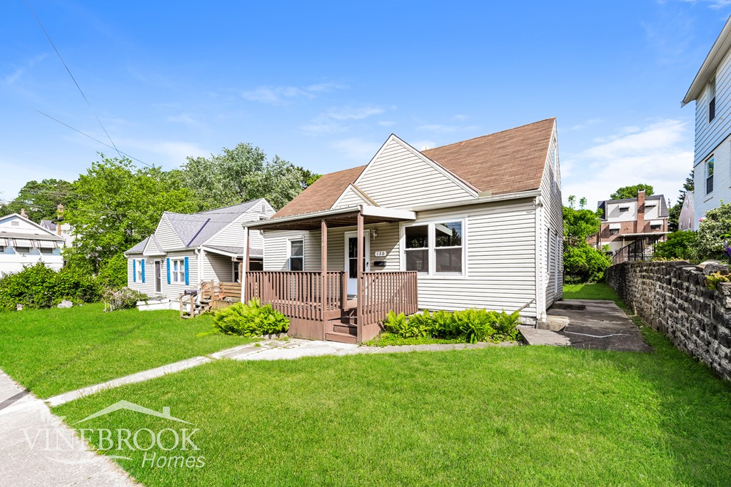 A house with a porch and a lawn in front.