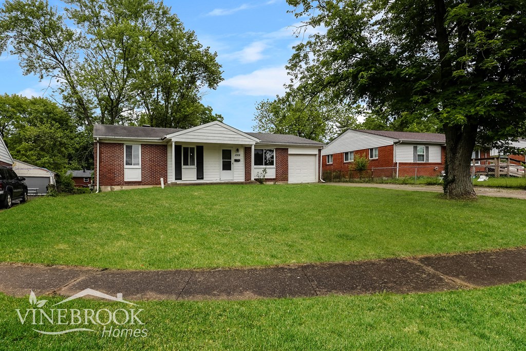 A Vinebrook Homes sign is on a grassy area in front of a house.