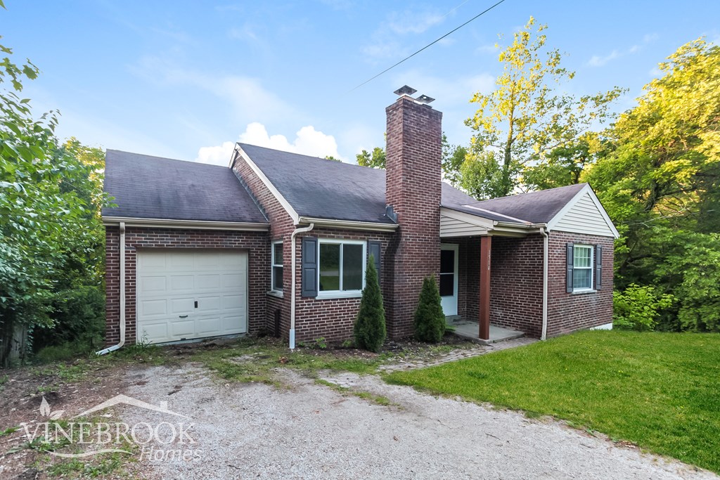 A house with a gravel driveway in front of it.