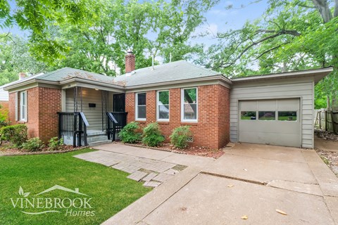 A brick house with a garage is for sale.