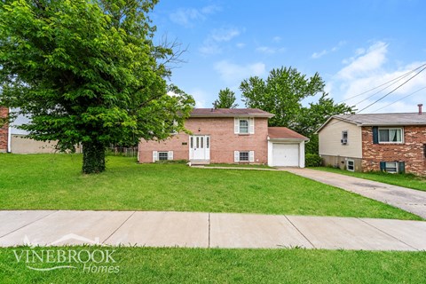 A house with a tree in front of it and a sign that says Vinebrook Homes.