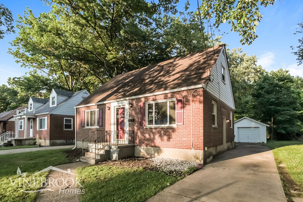 A house with a red brick exterior and a white garage door.