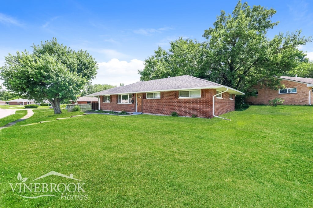 A house with a lawn in front of it and the words Vinebrook Homes written on the bottom left.