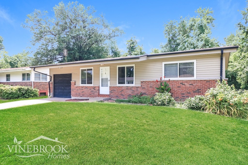 A Vinebrook Homes house with a well-kept lawn and trees in the background.