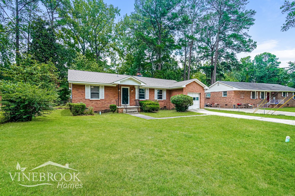 A Vinebrook Homes sign is on a lawn in front of a house.