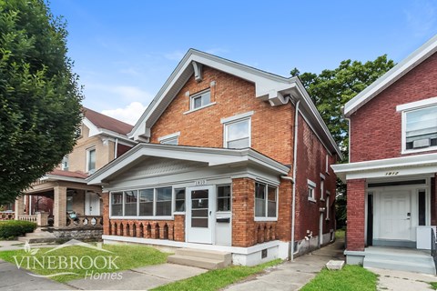 A brick house with the sign Vinebrook Homes in front.