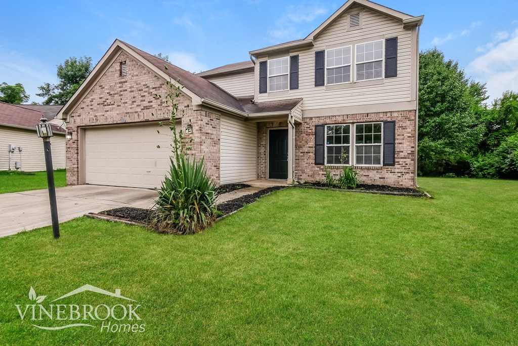A house with a driveway and a garage is for sale.