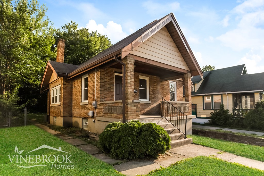 A brick house with a green lawn in front.