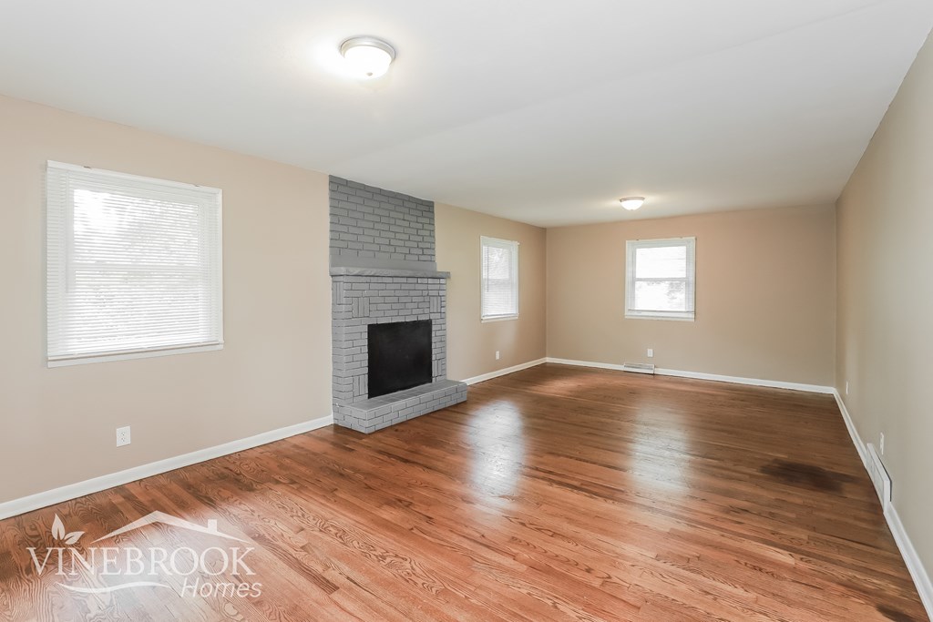 a living room with wood floors and a fireplace