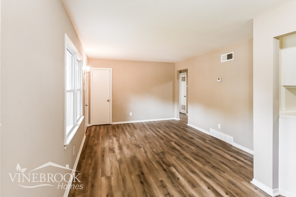 a living room with a hard wood floor and a window