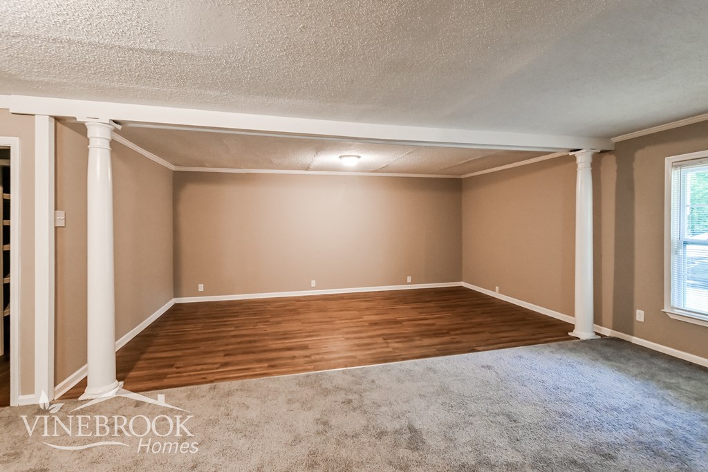 the living room after remodeling with wood flooring and pillars
