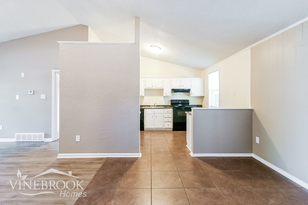 a renovated kitchen with white cabinets and a tiled floor