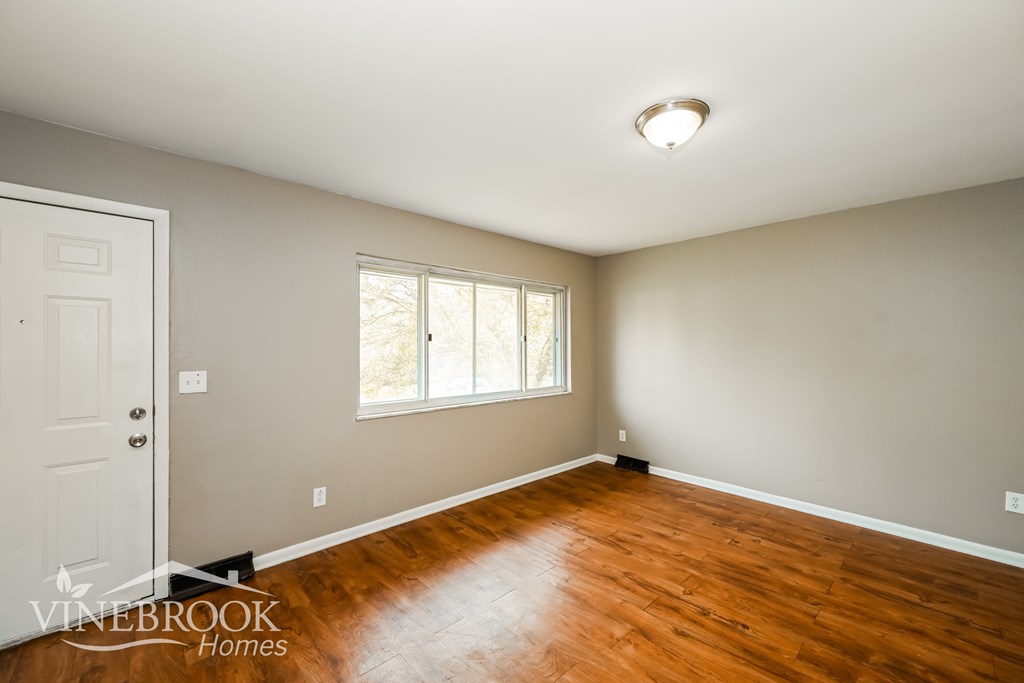 A room with a wooden floor and a window.