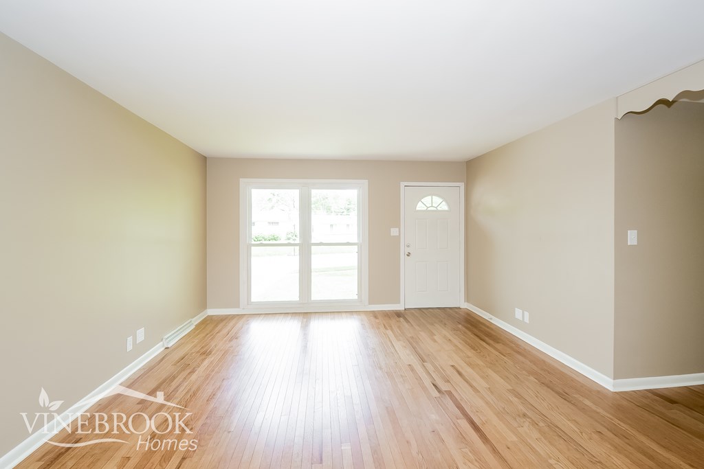 A room with wooden floors and a white door.