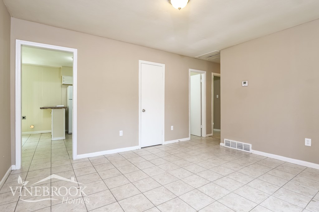 A spacious room with tile flooring and a Vinebrook Homes logo.