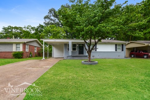 A Vinebrook Homes sign is on a lawn in front of a house.