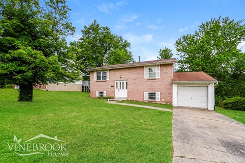 A house with a driveway and a garage is for sale.
