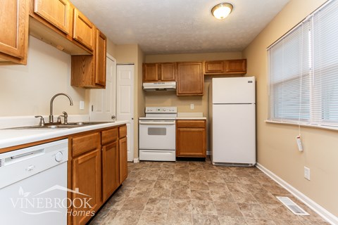 A kitchen with wooden cabinets and a white refrigerator.