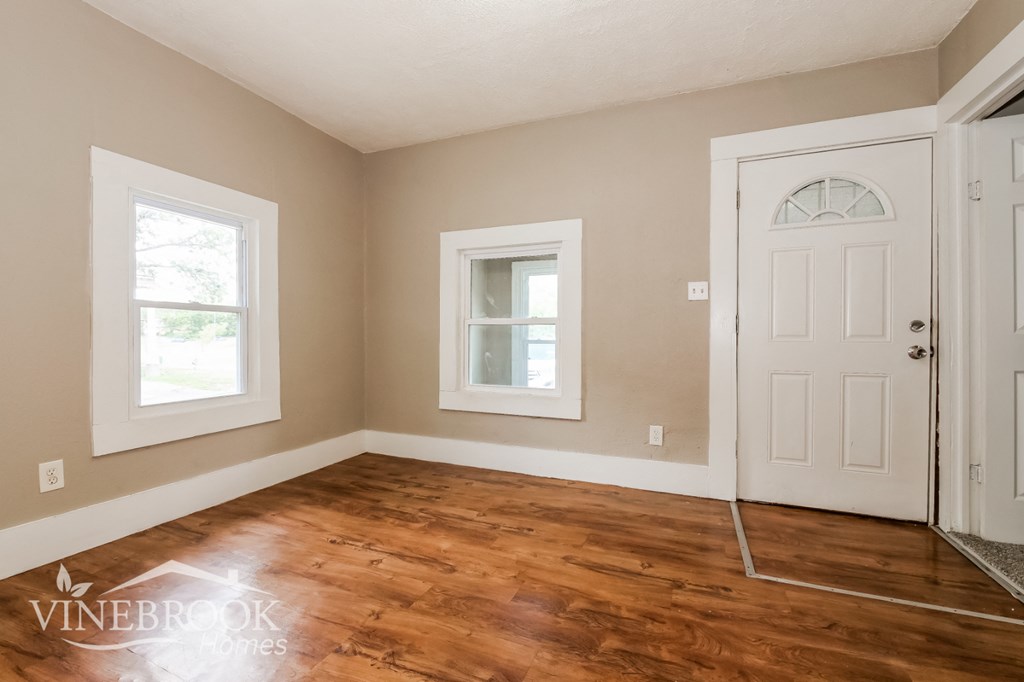 the living room of a home with a hardwood floor and a white door
