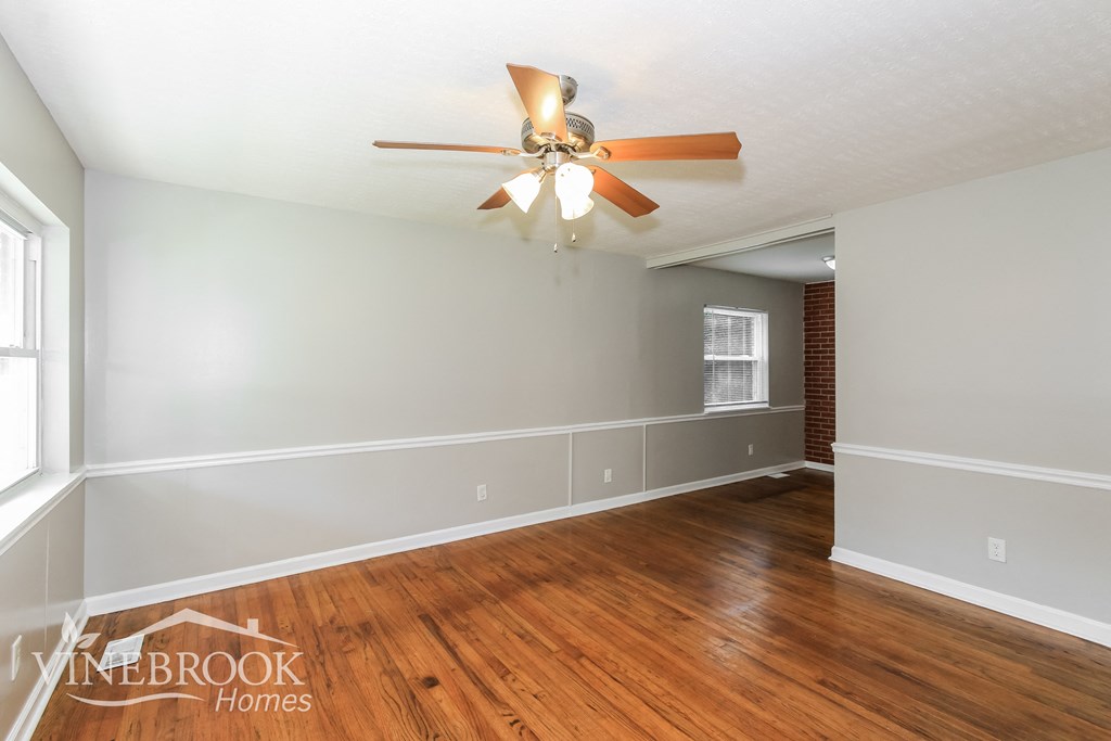 a living room with wood floors and a ceiling fan