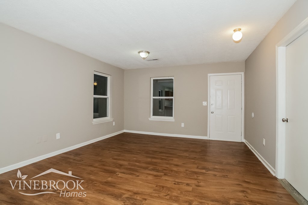 the living room of a home with a hardwood floor and a white door