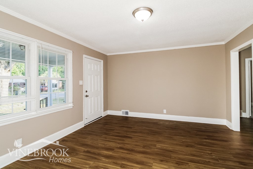 the living room of a house with wood floors and a white door