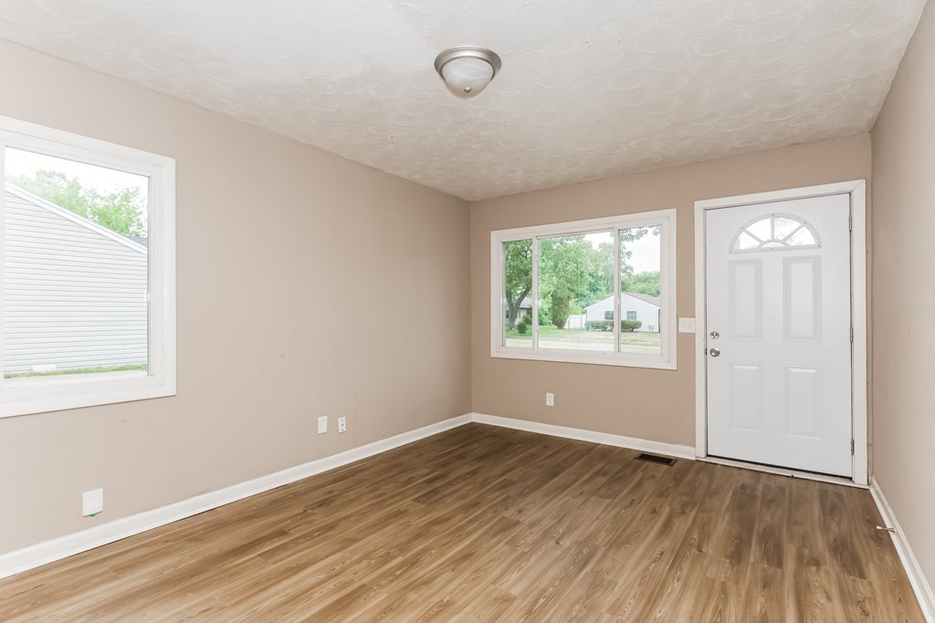an empty room with wooden floors and a white door