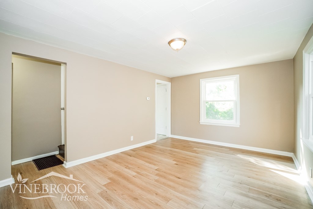 a living room with wood floors and a door to a closet